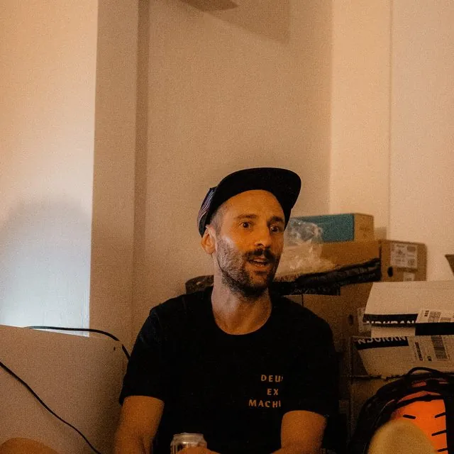 Matteo Pavana racconta, seduto a terra, durante il talk a Introspective Studio
